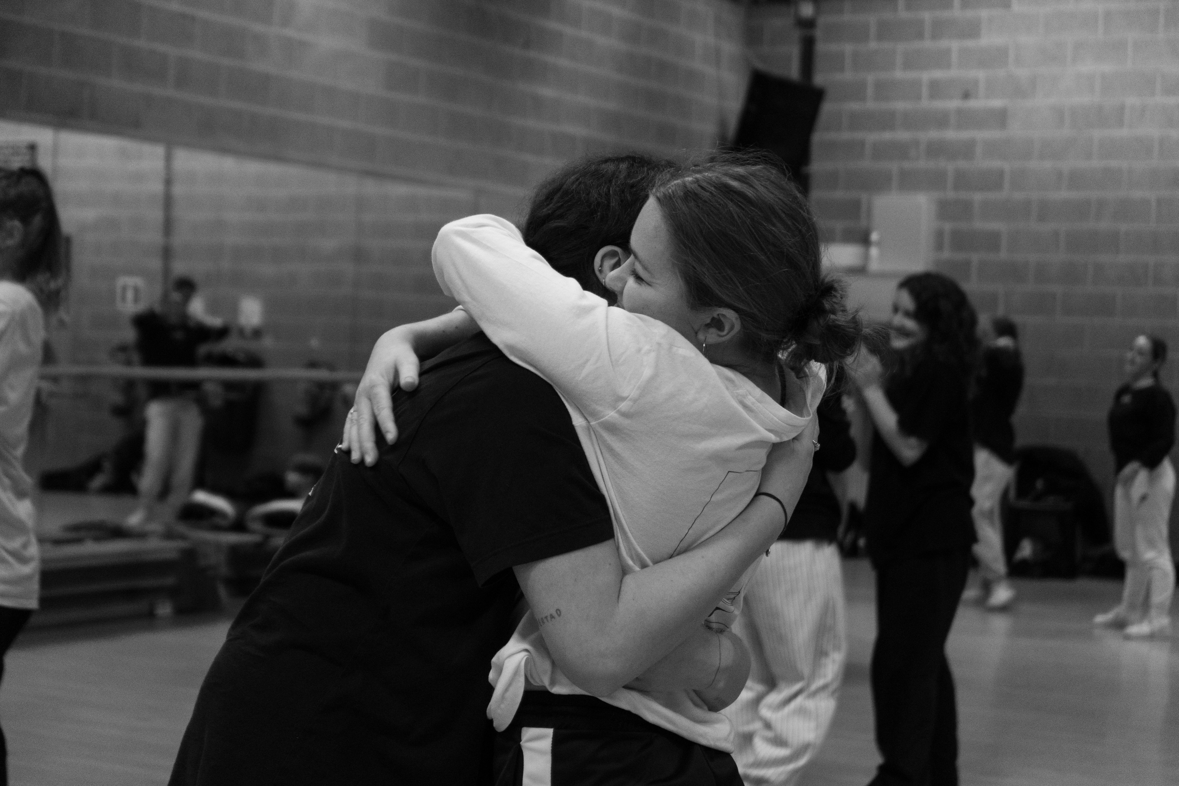 Two persons hugging it out during the Arta Intensive